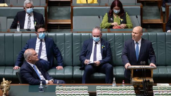 Treasurer John Frydenberg delivering the 2022 Federal Budget in Parliament, flanked by the prime minister and deputy prime minister