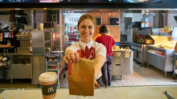 Young woman serves fast food over a McDonald's counter