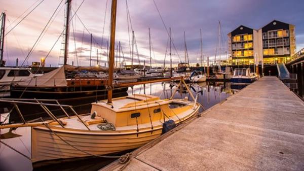 Launceston seaport in beautiful twilight sky with old small yacht in foreground.