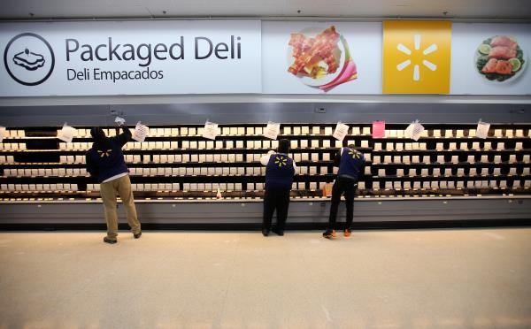 Employees sort shelving for food products as they prepare for the opening of a Walmart Super Center in  Compton, California