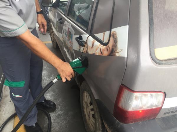A gas station worker fills up a car's tank with ethanol in Cuiaba