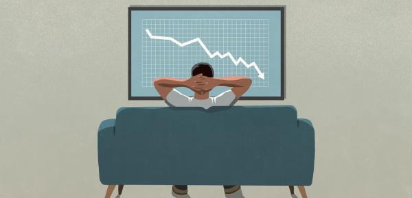 Man on sofa watching declining graph on TV