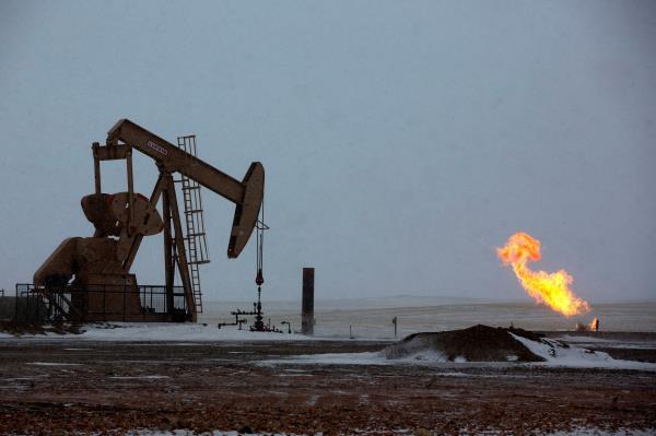 Natural gas flares are seen at an oil pump site outside of Williston