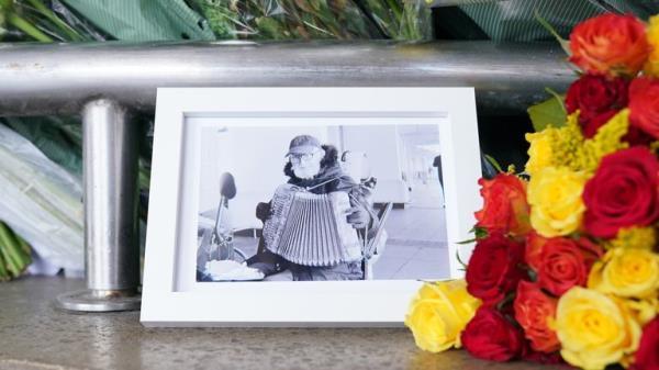 A picture of Thomas O'Halloran left amongst floral tributes outside Perivale Tesco, Greenford, where the 87-year-old, who was fatally stabbed in Greenford, west London on Tuesday, used to play his accordion. Picture date: Friday August 19, 2022.

