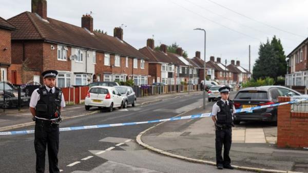 Police officers stand outside the house where a 9-years-old child was shot overnight in Liverpool, Britain August 23, 2022. REUTERS/Phil Noble
