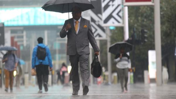 People walk along Wembley Way, north west London in the rain,, as the Met Office has issued a yellow warning for thunderstorms and heavy rain in south and eastern England, with driving conditions potentially affected by spray, standing water and even hail, as well as possible delays to train services, power cuts, flooding and lightning strikes. Picture date: Thursday August 25, 2022.

