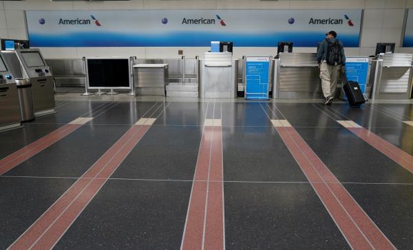 FILE PHOTO: Customer seeks assistance at American Airlines counter at Reagan National airport in Washington