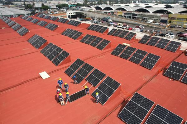 Workers install solar panels at the Central de Abastos wholesale market in Mexico City