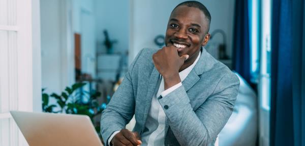 Confident man at table with laptop