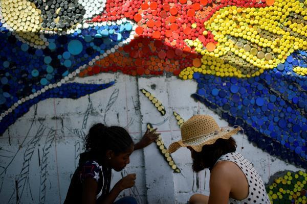 Venezuelan artist Oscar Olivares uses thousands of bottle caps to create colorful eco-mural, in Caracas