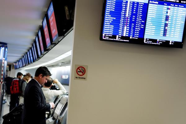 A man checks in at the United Airlines ticket counter at LaGuardia Airport in New York