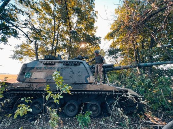 Ukrainian service member stands on a Russian 2S19 Msta-S self-propelled howitzer captured during a counteroffensive operation in Kharkiv region