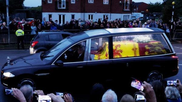 People watch the hearse carrying the coffin of Britain's Queen Elizabeth, following her death, after leaving RAF Northolt, in London, Britain September 13, 2022. REUTERS/Andrew Couldridge
