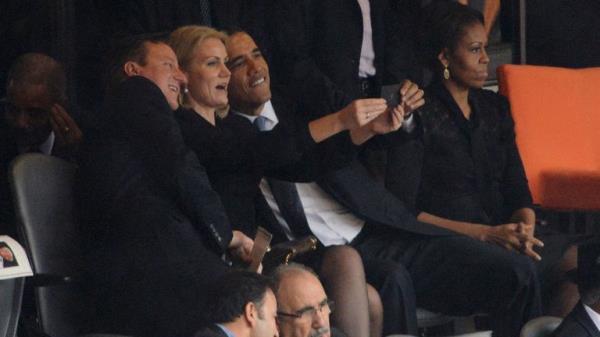 US President Barack Obama (R) and British Prime Minister David Cameron pose for a selfie picture with Denmark's Prime Minister Helle Thorning Schmidt (C) next to US First Lady Michelle Obama (R) during the memorial service of South African former president Nelson Mandela at the FNB Stadium (Soccer City) in Johannesburg on December 10, 2013. 
