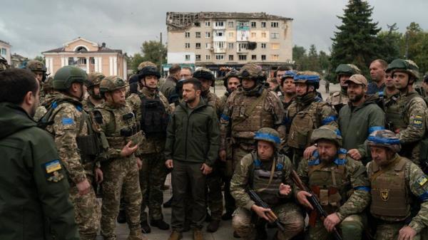 Ukrainian President Volodymyr Zelenskyy stands with soldiers after attending a national flag-raising ceremony in the freed Izium, Ukraine, Wednesday, Sept. 14, 2022. Pic: AP