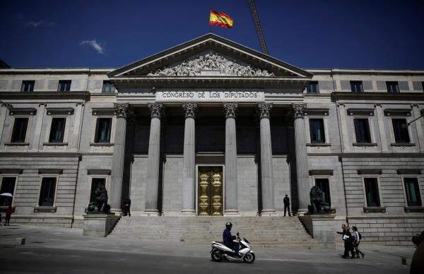 A Spanish flag waves over the Spanish parliament in Madrid