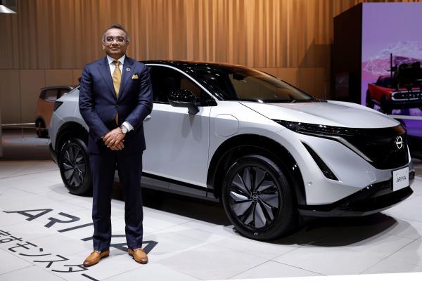 NISSAN Chief Operating Officer Ashwani Gupta stands next to a car at NISSAN Gallery in Yokohama