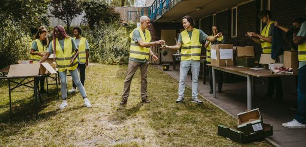volunteers helping each other while working in garden