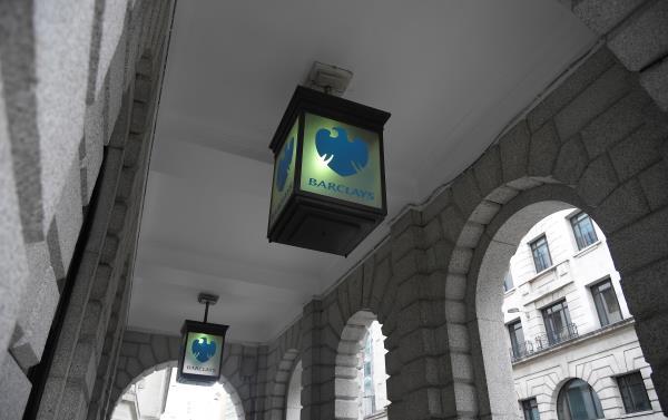 The logo of Barclays bank is seen on glass lamps outside of a branch of the bank in the City of London financial district in London