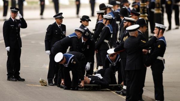 A police officer is stretchered away after collapsing on the day of state funeral and burial of Britain's Queen Elizabeth, in London, Britain, September 19, 2022 REUTERS/John Sibley
