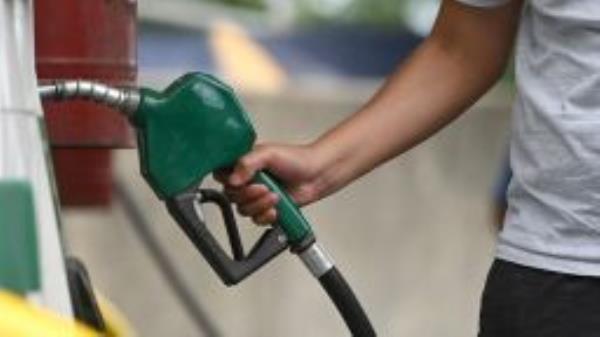 A motorist hold a gasoline nozzle at a service station in the Queens borough of New York City, NY, August 11, 2022. The national average price for a gallon of gas fell below $4.00 a gallon to its lowest level since March of 2022. 