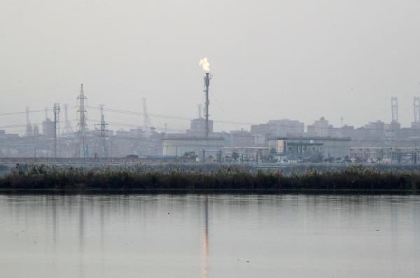 Flames shoot out of a chimney at Petroleum and Natural Gas company factories  by a salt lake at the Wadi al-Qamar (Moon Valley) along a highway of Alexandria