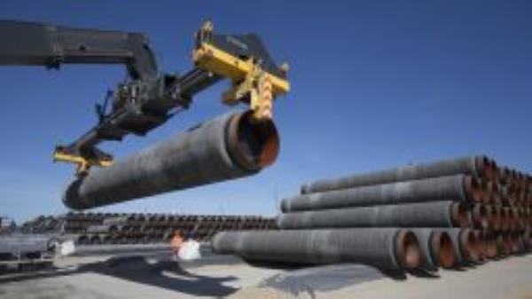 GERMANY, SASSNITZ - JUNE 05: Large pipes for the Baltic Sea pipeline Nord Stream 2 on a storage area in the ferry port of Sassnitz/Neu Mukran - Terminal Truck stacks the pipes. The pipes are sheathed with a concrete iron ore mixture. (Photo by Ulrich Baumgarten via Getty Images)