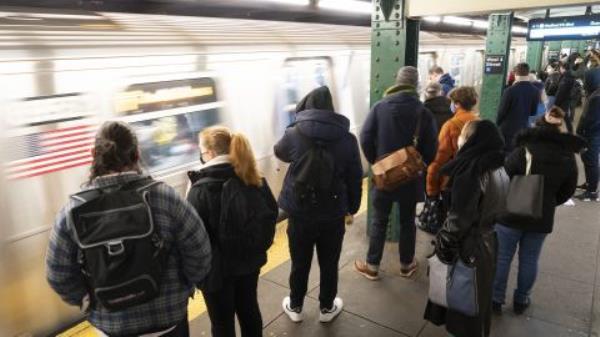 Commuters wait on the platform to board a subway at a station in New York on Monday, March 28, 2022. 