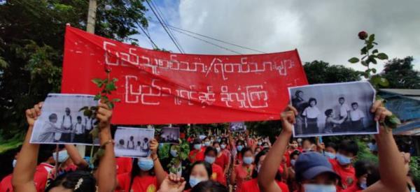 Women from the Rosy Women's Union hold a peaceful march holding up black and white photographs of children