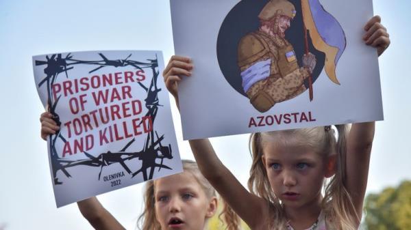 Children hold placards, as relatives and friends of defenders of the Azovstal Iron and Steel Works in Mariupol hold a rally demanding to recognise Russia as a state sponsor of terrorism after killing Ukrainian prisoners of war (POWs) in a prison in Olenivka, outside of Donetsk, as Russia's attack on Ukraine continues, in Kyiv, Ukraine August 5, 2022. REUTERS/Pavlo Palamarchuk