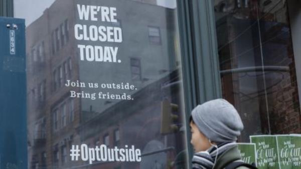 A woman walks past a closed REI store in New York on Black Friday, 2016.