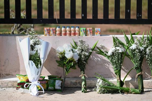 Bouquets of flowers and children's drinks are placed outside a nursery in Thailand on October 7 2022, the day after a mass killing by a former police officer in northeastern Nong Bua Lamphu province 