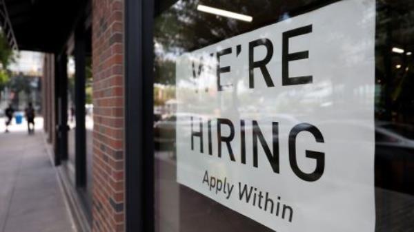 A hiring sign posted on the window of a retail store in Washington, D.C.