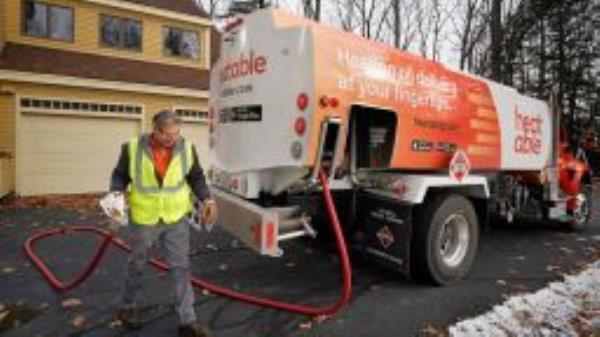 An oil delivery driver for Heatable, walks a hose back to the side of an oil delivery truck while delivering oil to a home in Falmouth on Thursday, November 14, 2019.