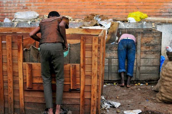 Boys scavenge for leftover fruits from delivery containers outside a fruit market in the southern Indian city of Bangalore October 17, 2014.