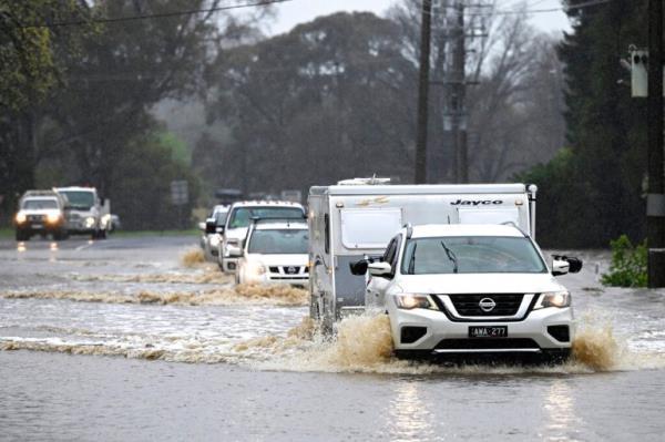 Cars slosh through a flooded road in Heathcote in Australia's Victoria State on October 13, 2022 