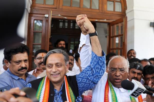 Mallikarjun Kharge, newly elected president of the Congress party, India's main opposition party, raises his hand with party colleague Shashi Tharoor at Kharge��s residence in New Delhi, India,