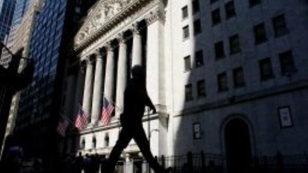 People make their way near to The New York Stock Exchange, on July 12, 2022 in New York. 
