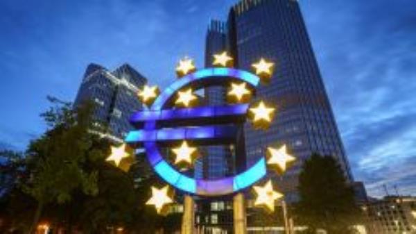 The large euro symbol in front of the former headquarters of the European Central Bank (ECB, r) glows in the early morning. 