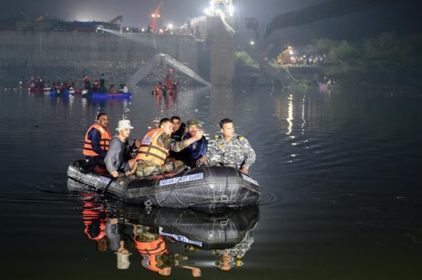 Indian rescue personnel conduct search operations after a bridge across the river Machchhu collapsed in Morbi