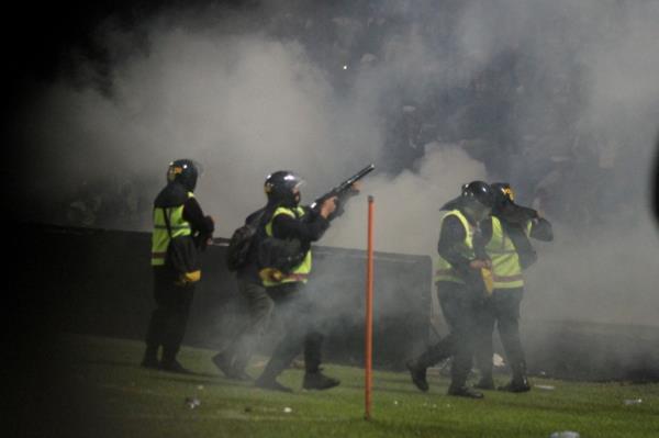 A riot police officer fires tear gas during a riot after the league BRI Liga 1 football match between Arema vs Persebaya at Kanjuruhan Stadium in Malang, East Java province, Indonesia, October 2, 2022.