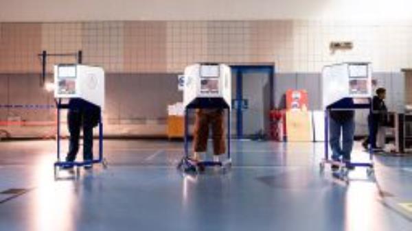 Voters mark their ballot in a privacy booth at West Side High School during early voting in New York City.