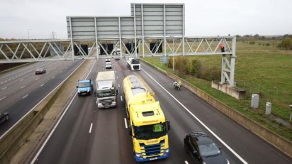 Activists from Just Stop Oil climbing a gantry on the M25 highway near London Colney in Hertfordshire. 