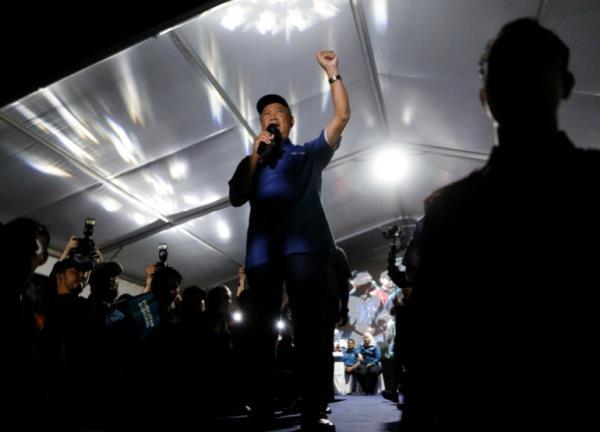 Muhyuddin Yassin, a former Malaysian prime minister, raises his arm as he speaks at a nighttime rally in Kuala Lumpur, Malaysia.