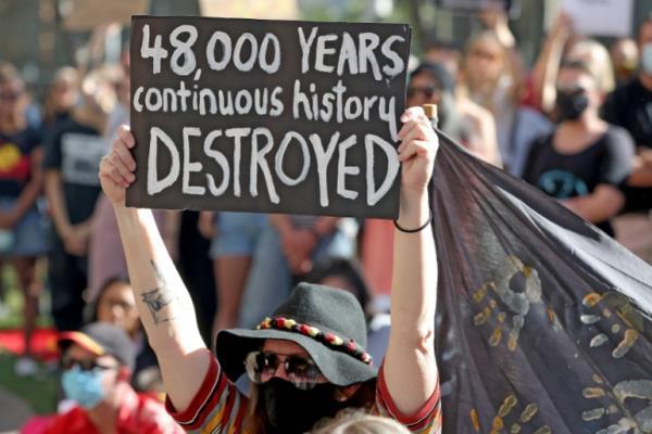 Protesters rallying against Rio Tinto, and carrying a sign saying '48,000 years continuous history destroyed' 