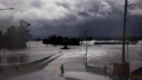 SYDNEY, AUSTRALIA - JULY 04: People view the flooded Windsor Bridge along the Hawkesbury River in the suburb of Windsor, on July 04, 2022 in Sydney, Australia. Thousands of residents were forced to leave their homes overnight and a number of evacuation orders are in place across Sydney as heavy rain and flooding continues. (Photo by Jenny Evans/Getty Images)