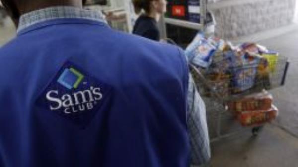 In this Sept. 9, 2010 file photo, a store associate watches as a customer leaves with her purchases at Sam's Club in Jackson, Miss.