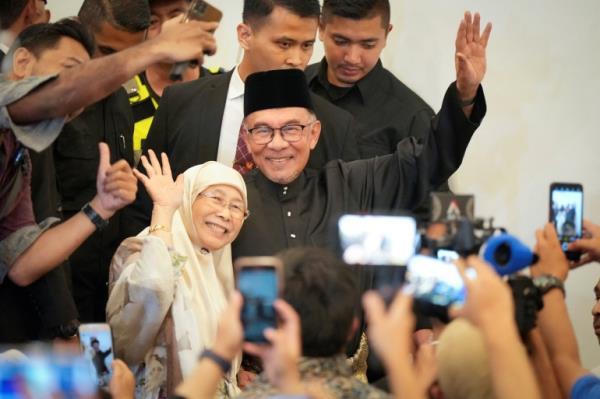 Malaysia's newly appointed Prime Minister Anwar Ibrahim and his wife Wan Azizah wave as they arrive at a gathering&nbsp;in Kuala Lumpur, Malaysia