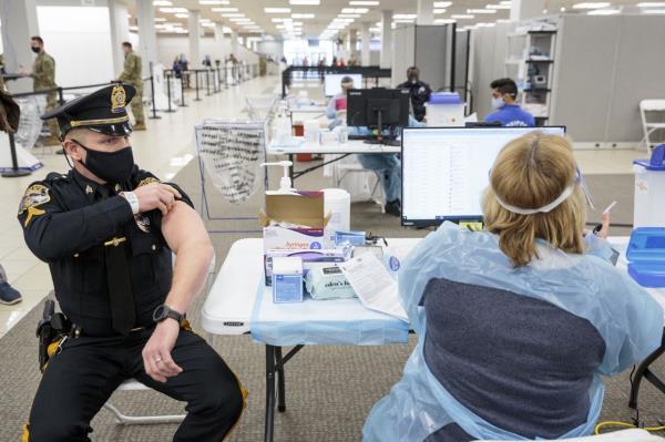 A police sergeant receives a Covid-19 vaccination at the Morris County Covid-19 vaccine "mega" site located in a former Sears store at the Townsquare Mall in Rockaway, New Jersey, on Jan. 8, 2021.