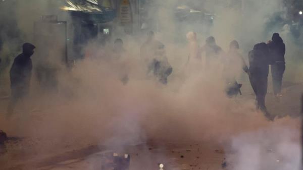 Clashes in Brussels after the World Cup football match between Belgium and Morocco - Brussels, Belgium - November 27, 2022 A group of people that the police are trying to disperse can be seen in the smoke during clashes after the World Cup match between Belgium and Morocco REUTERS/Yves Herman
